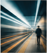 A person moving through a bright corridor, representing speed with direction